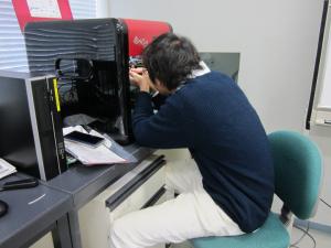 3Dプリンタから部品を取り出す学生の写真