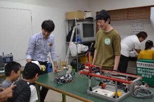 サソリロボットの実演をする学生の写真